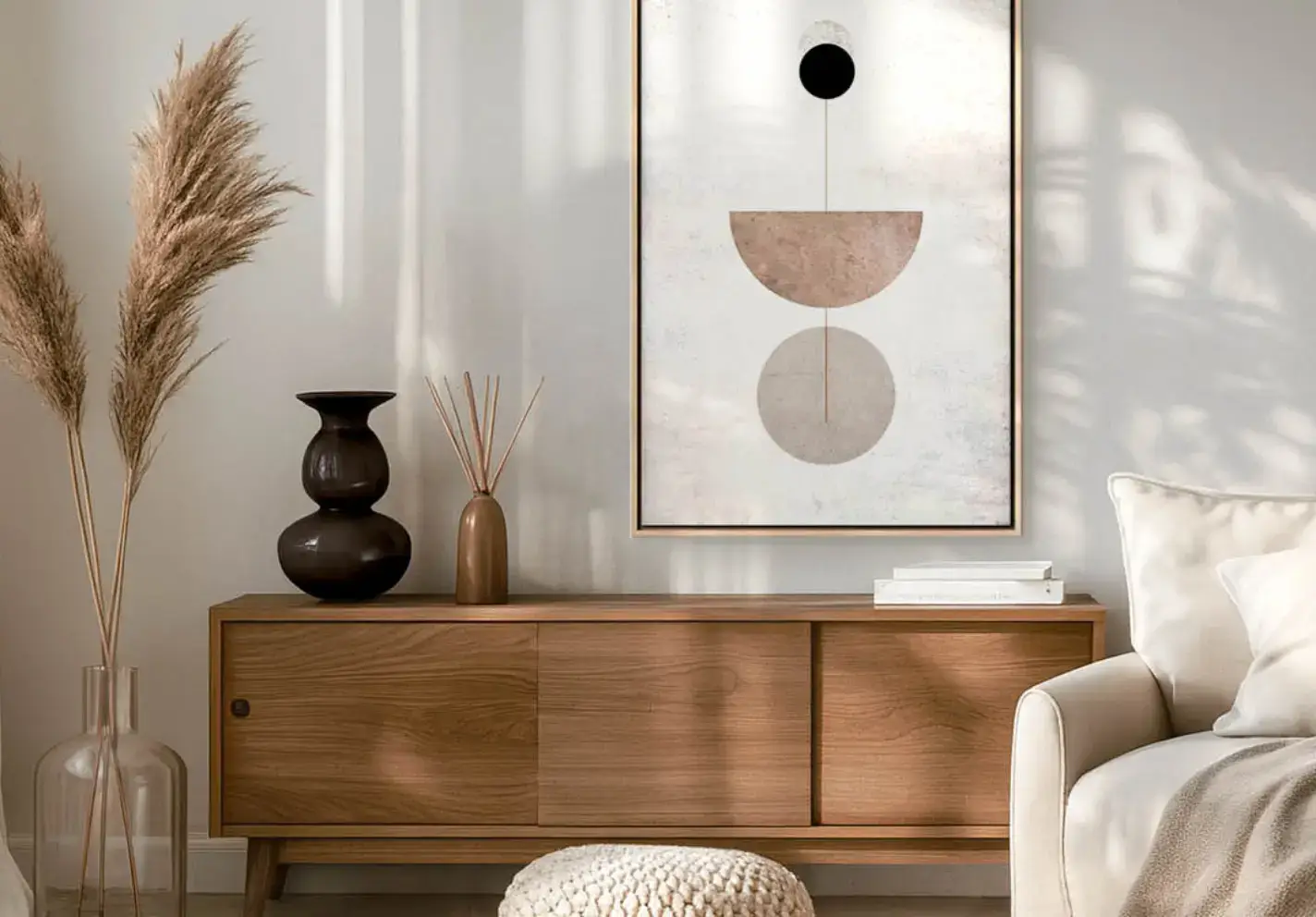 Boho Living Room with Abstract Painting and Pampas Grass This interior features a wooden chest of drawers, supported by ceramic vases and fluffy pampas grass. Above the cabinet hangs an abstract painting featuring geometric shapes in earthy tones.